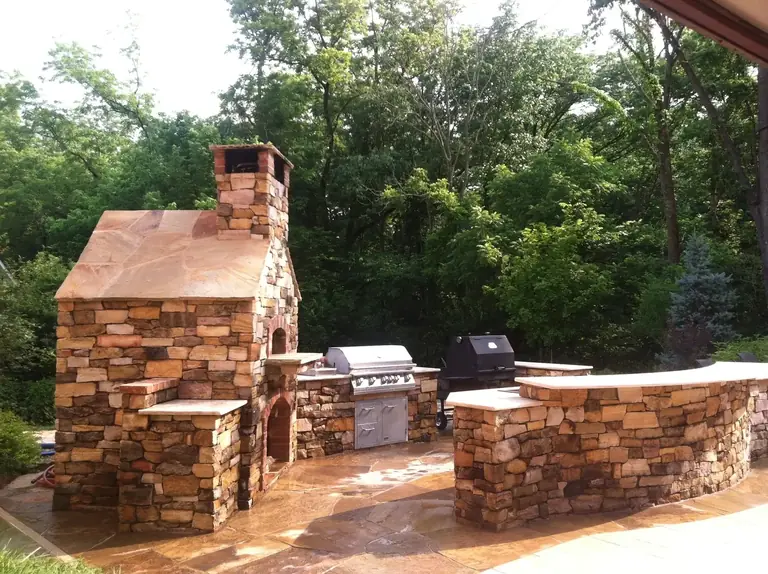 Stone outdoor kitchen with built-in grill by Landscape St. Louis